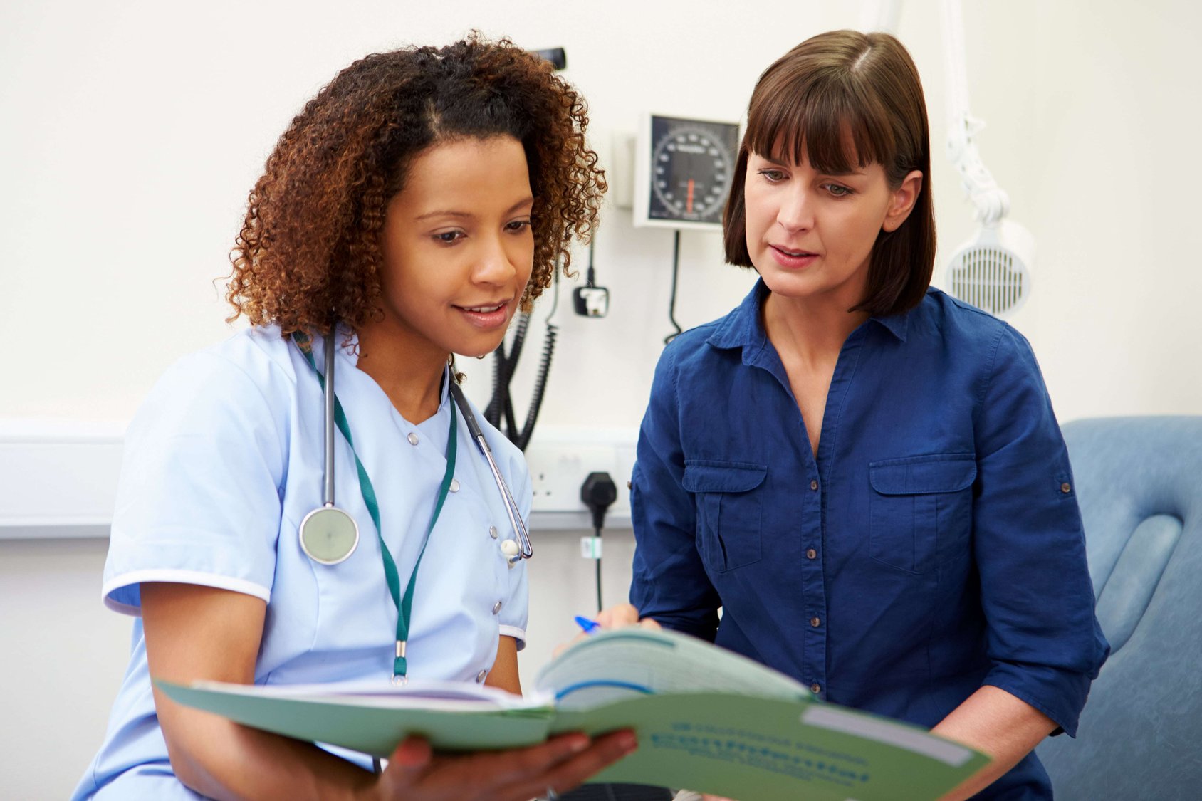 nurse going over paperwork with patient-min